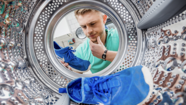 Header Bild Haushaltspflege Pressebereich Turnschuhe in Waschmaschine